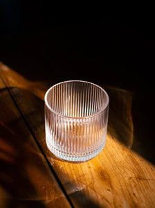 close up of empty glassware in bright sunlight on a warn and warm wood surface