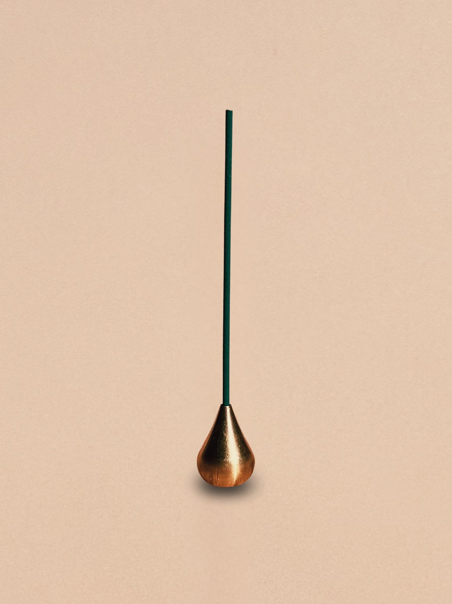Brass waterdrop incense holder shown alone against a neutral background.
