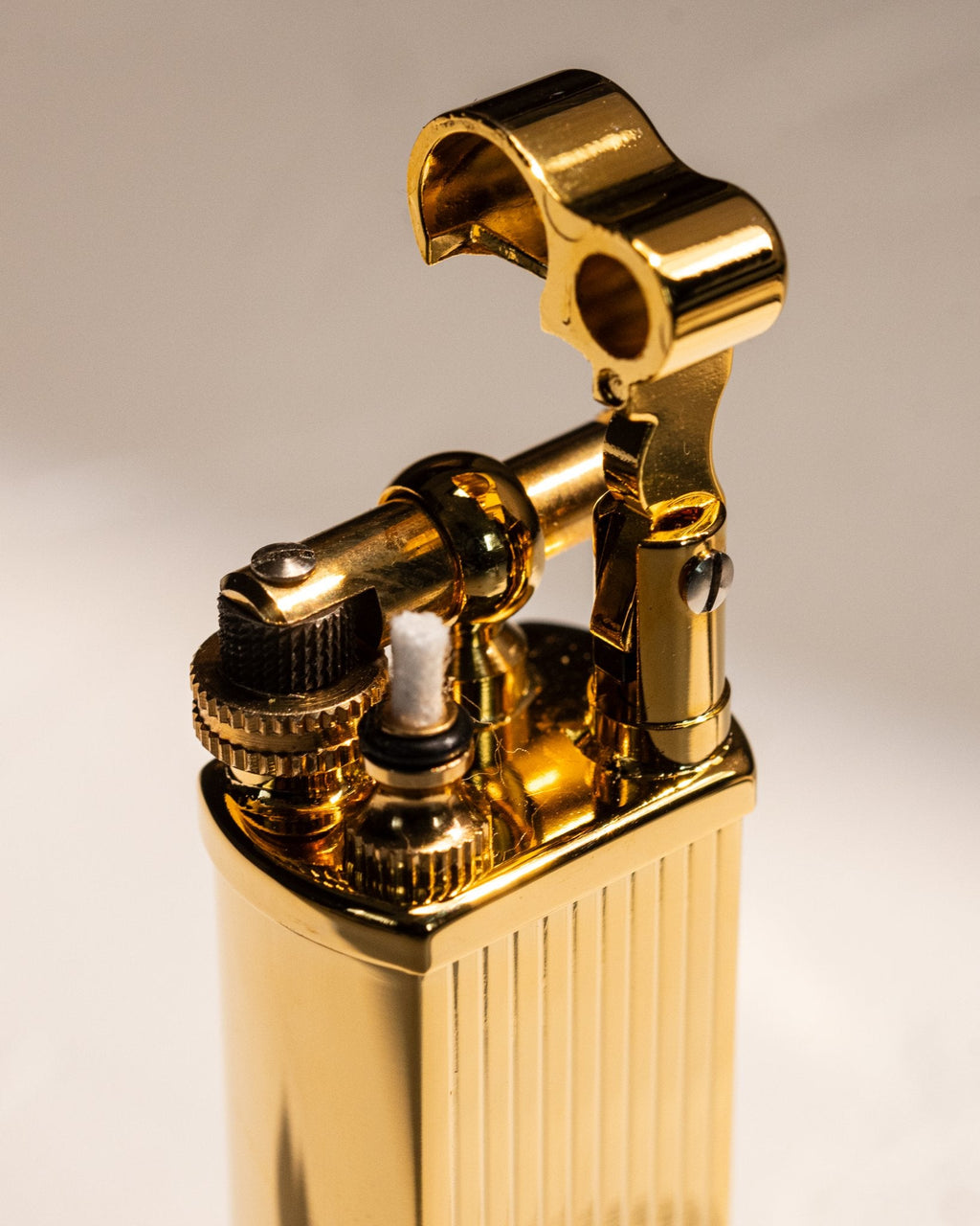 Close-up of gold Bolbo Striped lighter ignition assembly and flint wheel