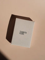 Tsubota Pearl Bolbo lighter retail box shown alone, photographed on a neutral background.