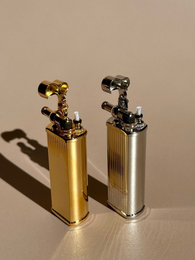 Brass and chrome Tsubota Pearl Bolbo lighters photographed side by side, showing fluted body design.
