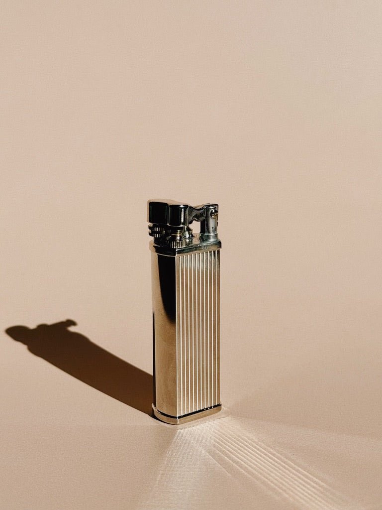 Striped Silver Tsubota Pearl Bolbo lighter standing upright, photographed with soft shadow on a neutral backdrop.
