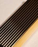 Detailed view of gold Bolbo Striped lighter with finely machined fluted finish
