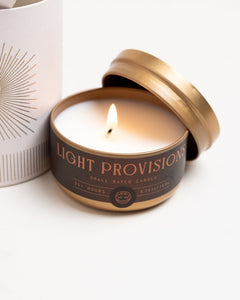 Open Tobacco & Walnut travel tin candle showing smooth white wax and gold lid on white background.