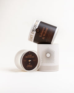 Tobacco Walnut open packaging beside signature glass vessel and dust cover - both unlit