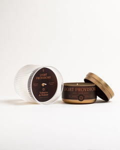 Open Light Provisions travel tin displayed next to bespoke crystal glass tumbler, with tobacco walnut dust cover