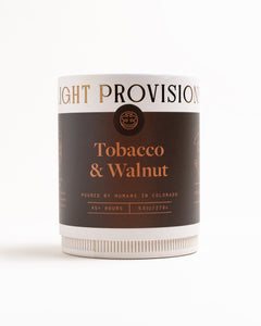 Tobacco & Walnut 9.5 oz glass tumbler candle packaging with brown label and copper foil lettering on white background.