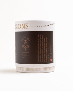 Side view of Tobacco & Walnut flagship candle box showing gold foil logo, collection name = Flagship, and scent description