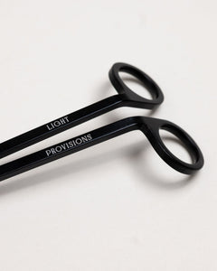 Close-up of black wick trimmer handles engraved with “Light Provisions” branding.