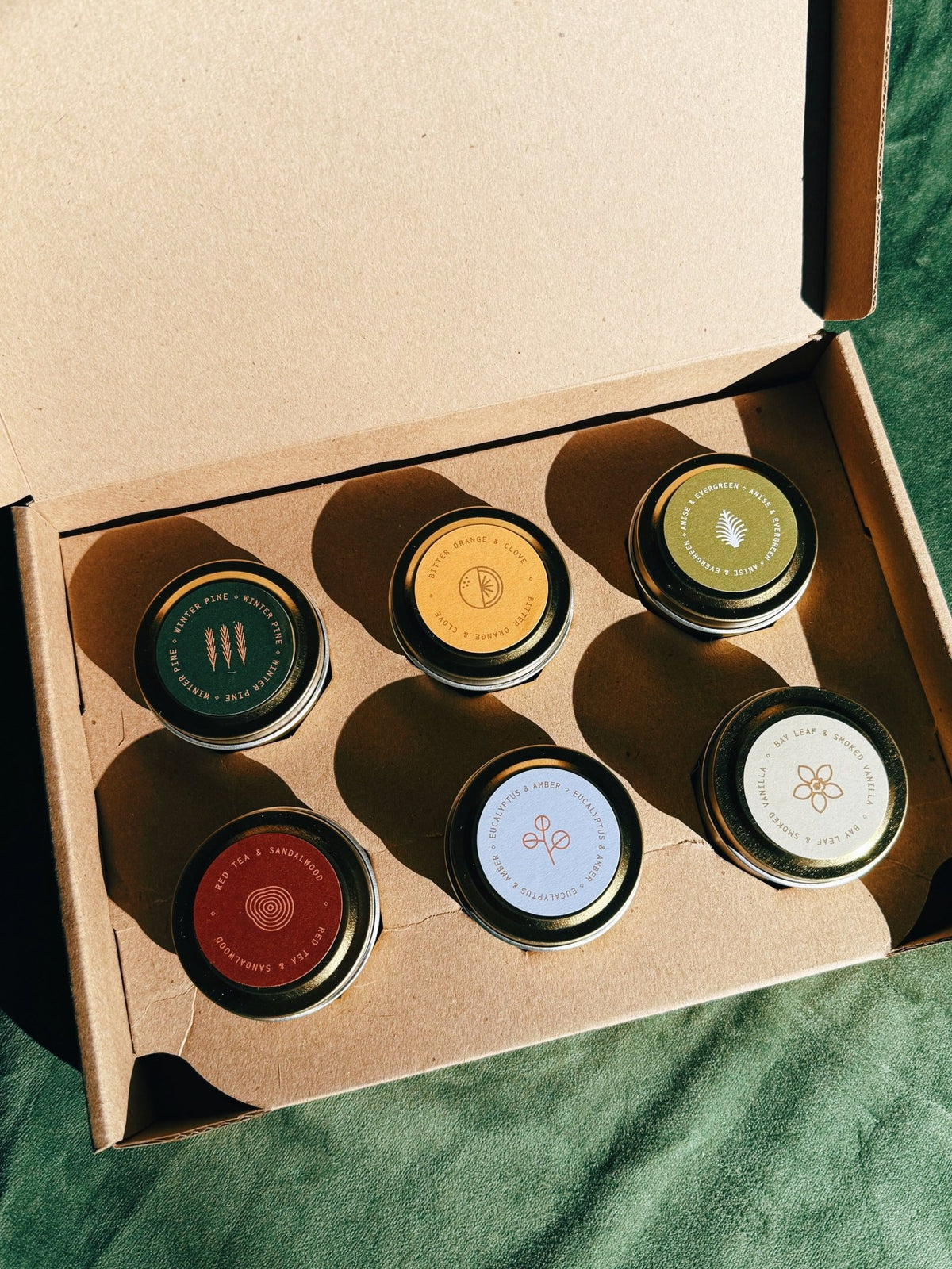 Winter Discovery Sample Pack shown open with multiple candle tins arranged inside the box.