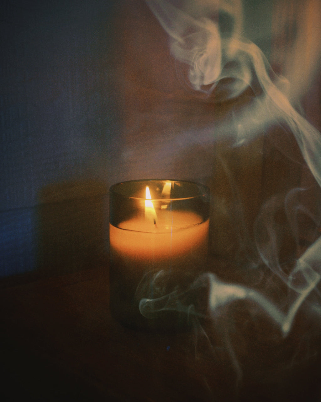 close up of burning light provisions woodsmoke candle with smoke in foreground and background