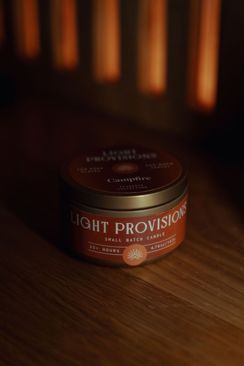 Campfire Candle 4.75 oz travel tin with brown label styled on wood surface