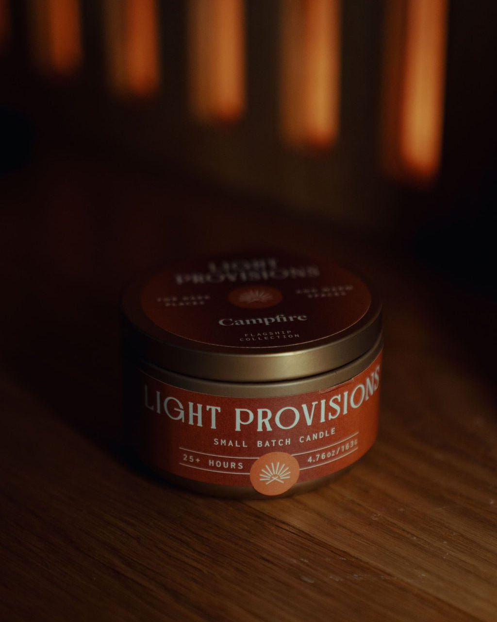 Campfire Candle 4.75 oz travel tin with brown label styled on wood surface
