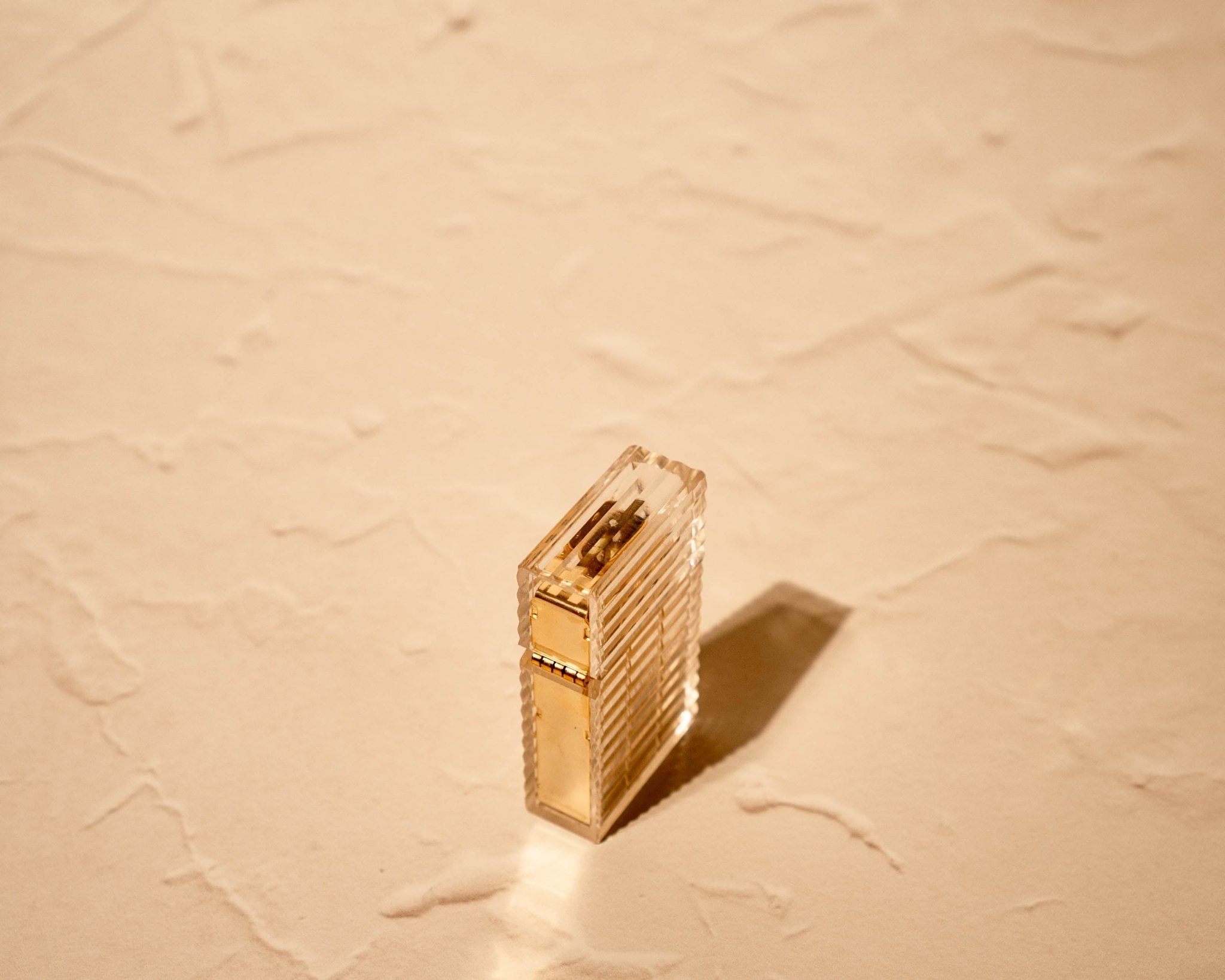 Latitude Hard-edge Lighter by Tsubota Pearl standing upright, clear ridged-cut with gold brass interior, made in Japan