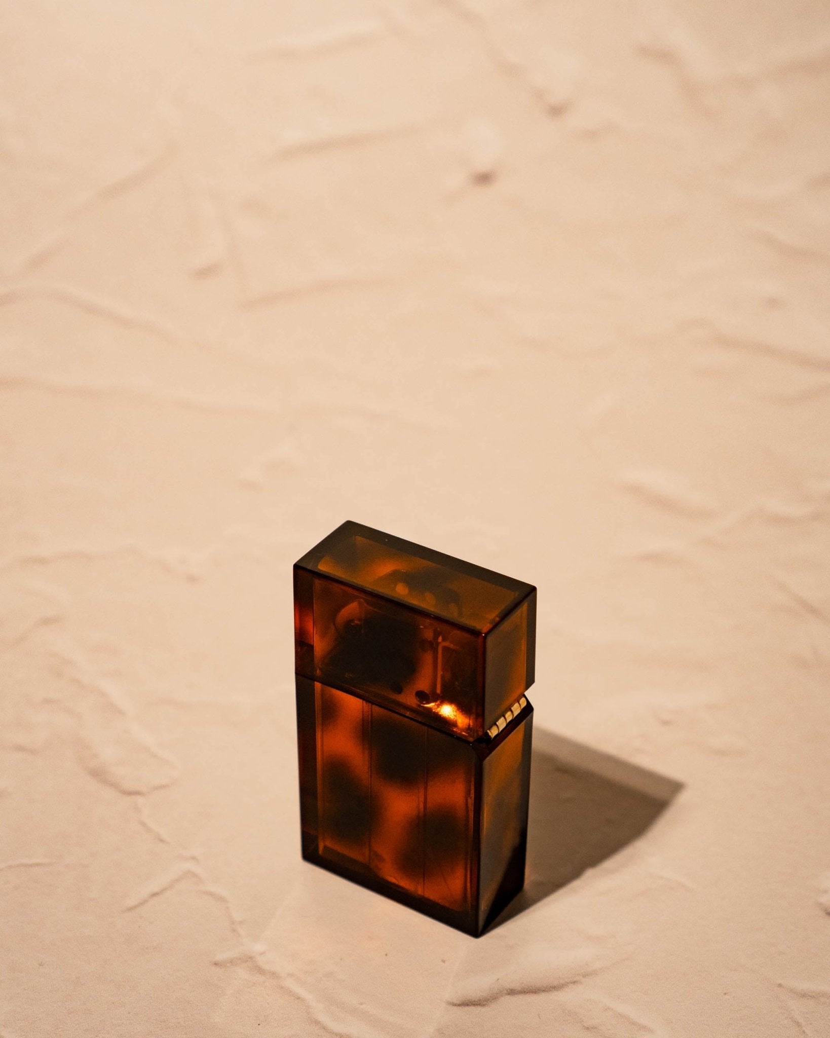 Tsubota Pearl Hard-edge Lighter marbled amber tortoise pattern closed on neutral surface, made in Japan