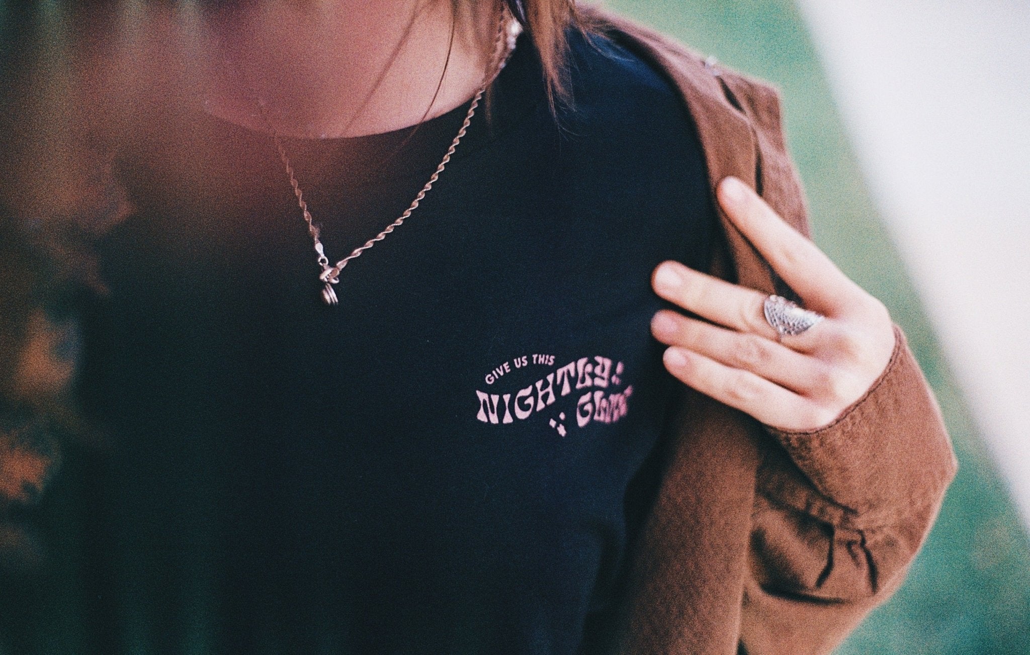Front of Light Provisions moth shirt with Give us this nightly glow text.