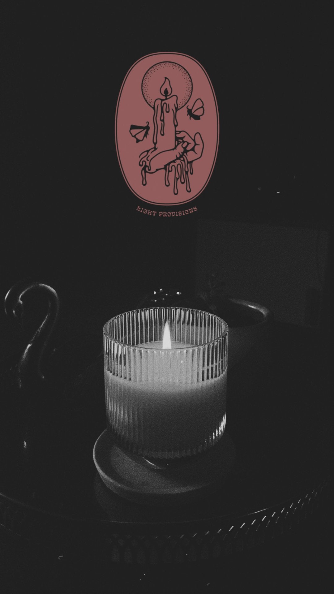 Moody lit candle graphic in black and white with moth graphic