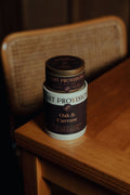 Oak and Currant Candle in 9.5 oz ribbed glass tumbler with dark label on wooden table