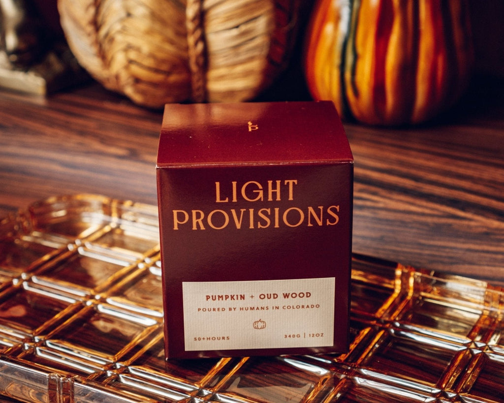 Pumpkin & Oud Wood Candle sitting on vintage amber tray with pumpkins in background